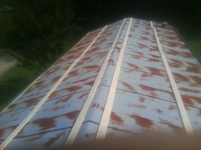 Rusted metal roof panels with new wood purlins before replacement — Storm Damage Roof Repair in Braggs by Roofing Brothers