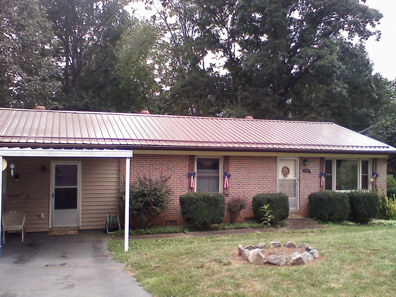 Bronze metal roof and carport on a brick ranch home — Roof Repair work by our crew in Braggs