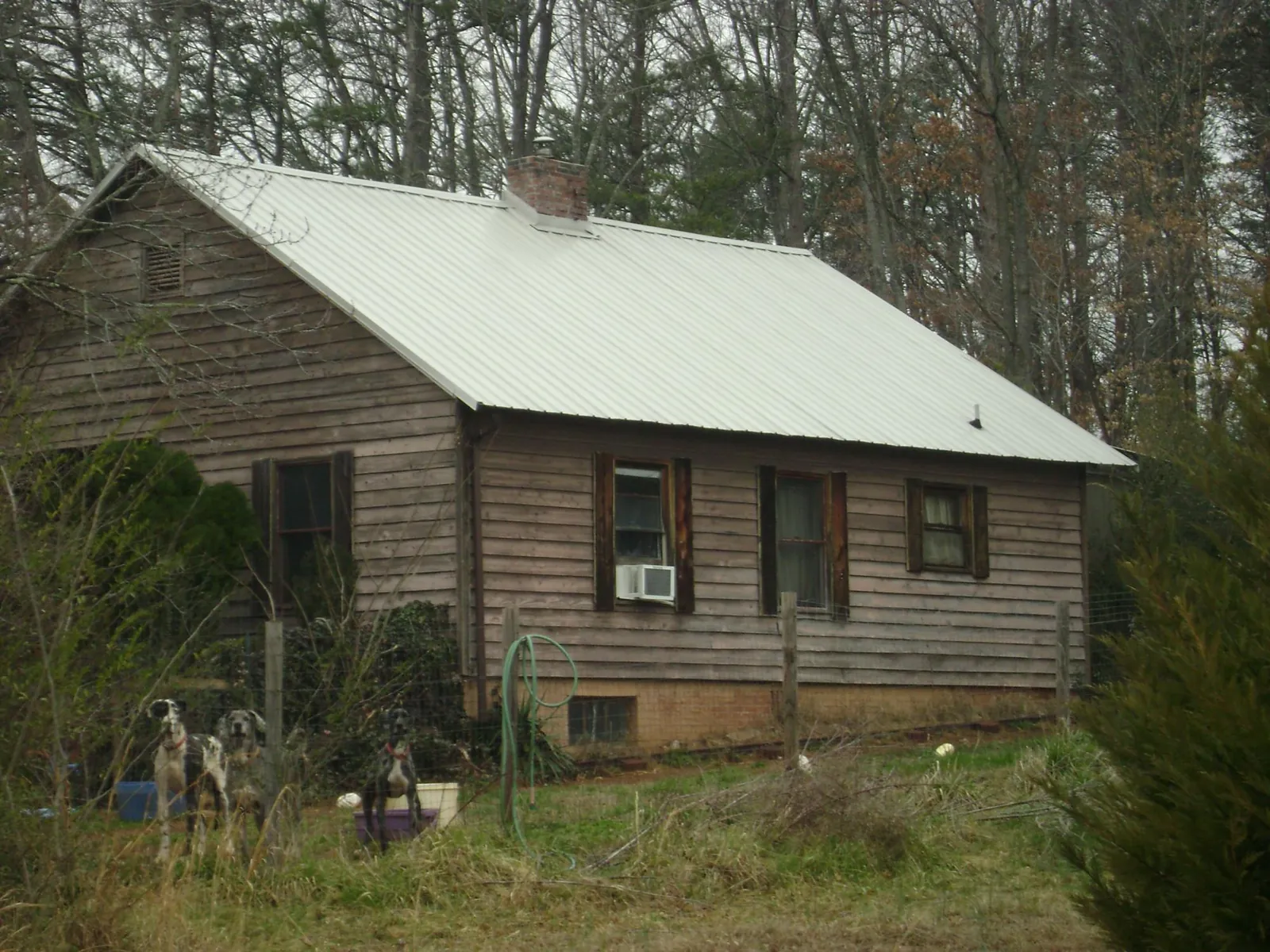 White metal roof on an old wood sided farmhouse, from a Metal Roof Installation job in Braggs